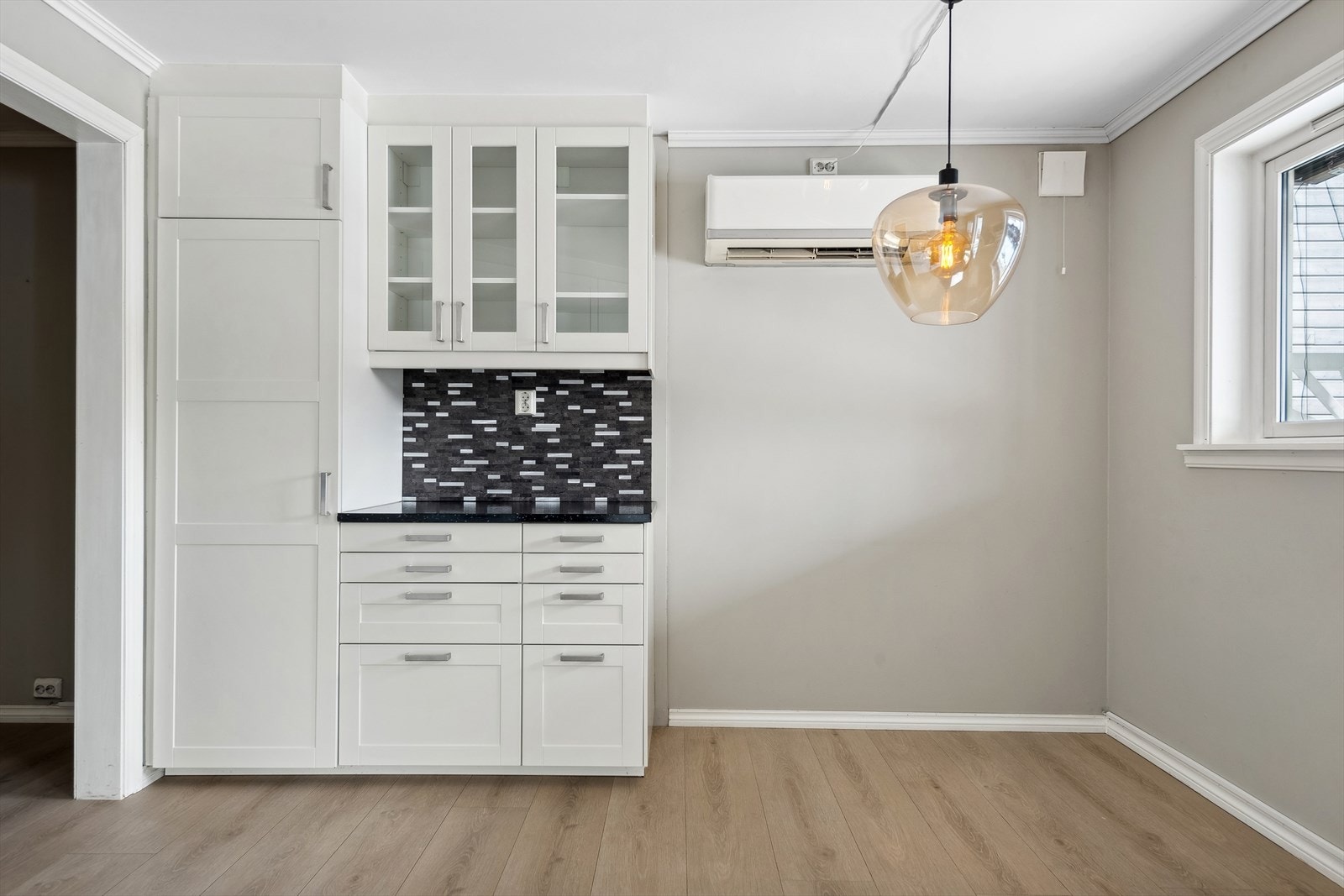 Innredningen har hvite profilerte fronter og laminert benkeplate med nedfelt vask. Galleribilde