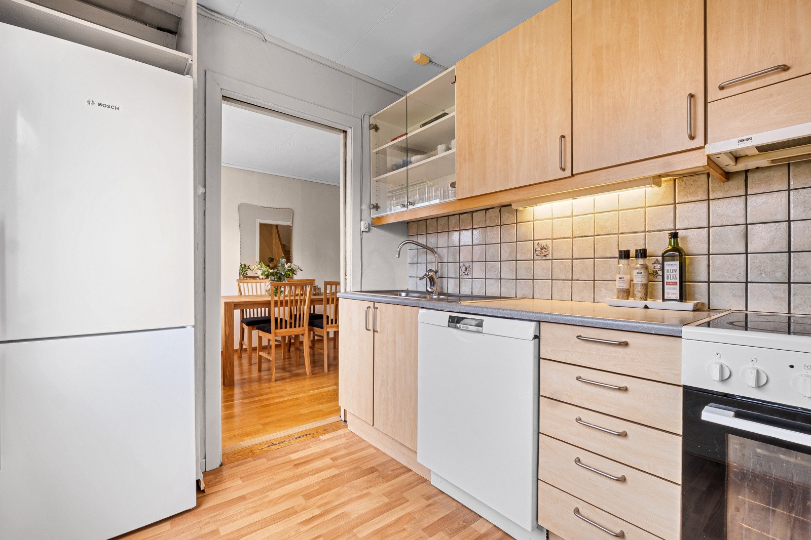 Kjøkkenet ligger i et eget rom og er innredet med glatte fronter, laminat benkeplate og kjøkkenventilator med avtrekk ut. Galleribilde