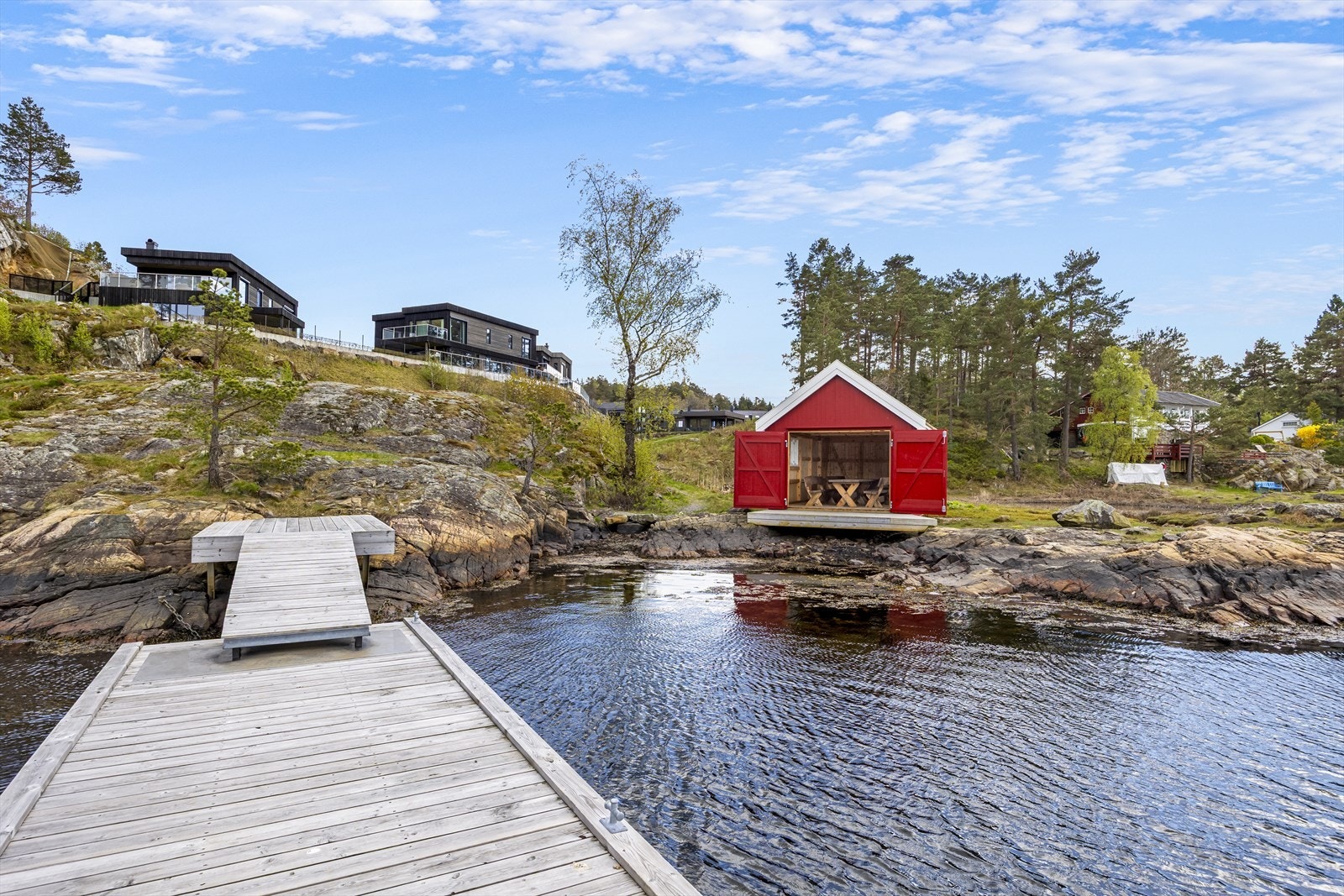 Like nedenfor boligene ligger en idyllisk sandstrand med badebrygge og sjøbod til felles glede med naboer. Galleribilde