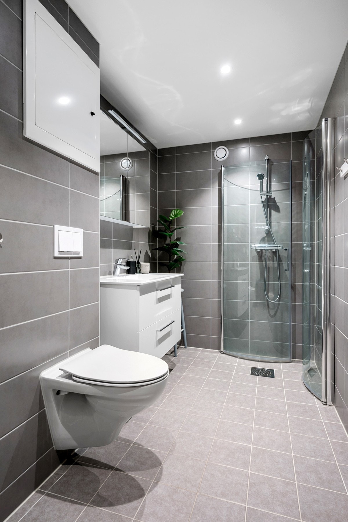 Delikat, flislagt bad med dusjplass med innsvingbare dører av glass, servant m/over-og underskap og vegghengt wc. Gulvvarme og downlights. Badet ble pusset opp i regi av borettslaget i 2020. Galleribilde