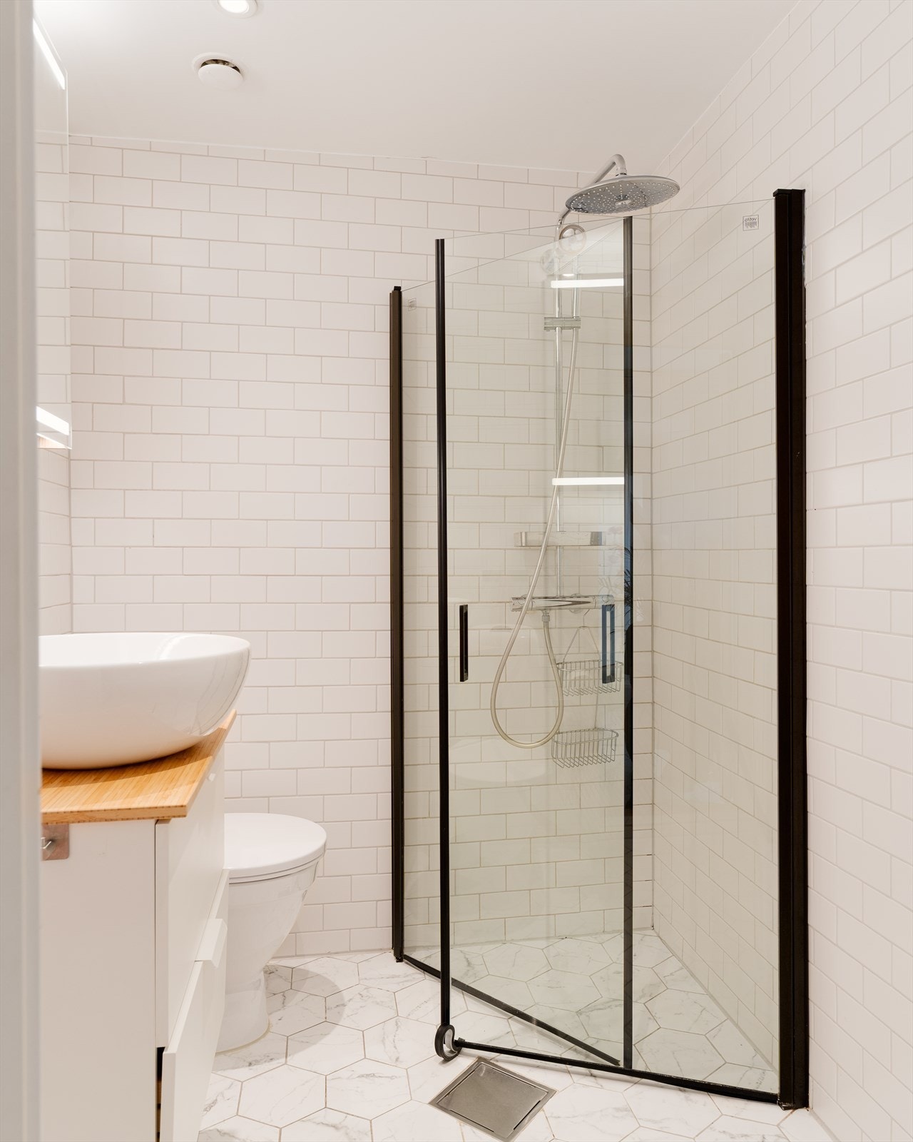 Lekkert, fliselagt baderom med varmekabler i gulv og downlights i himling. Galleribilde