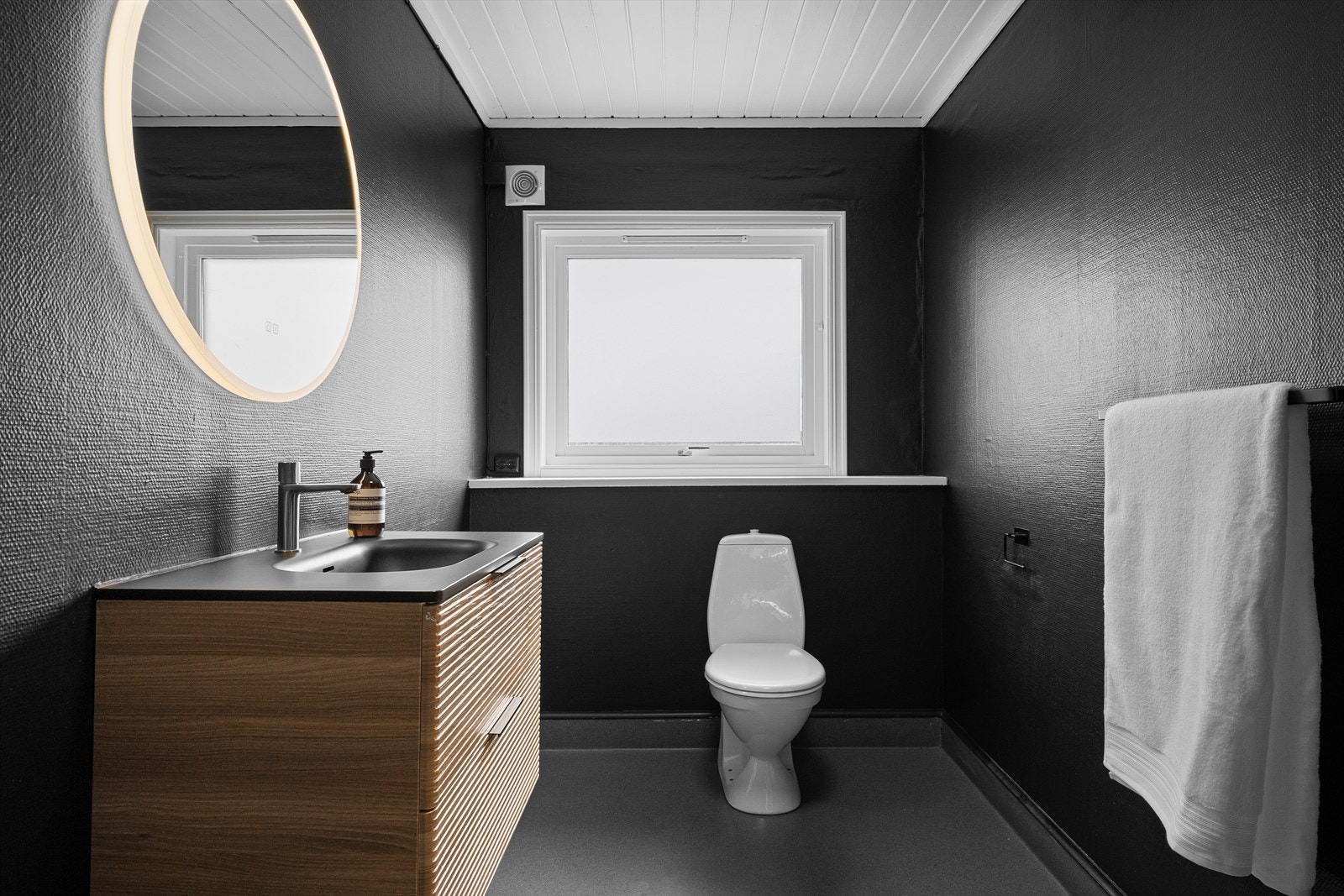 Badet i andre etasje har en stilren innredning med vegghengt toalett og et stort speil med belysning. Galleribilde