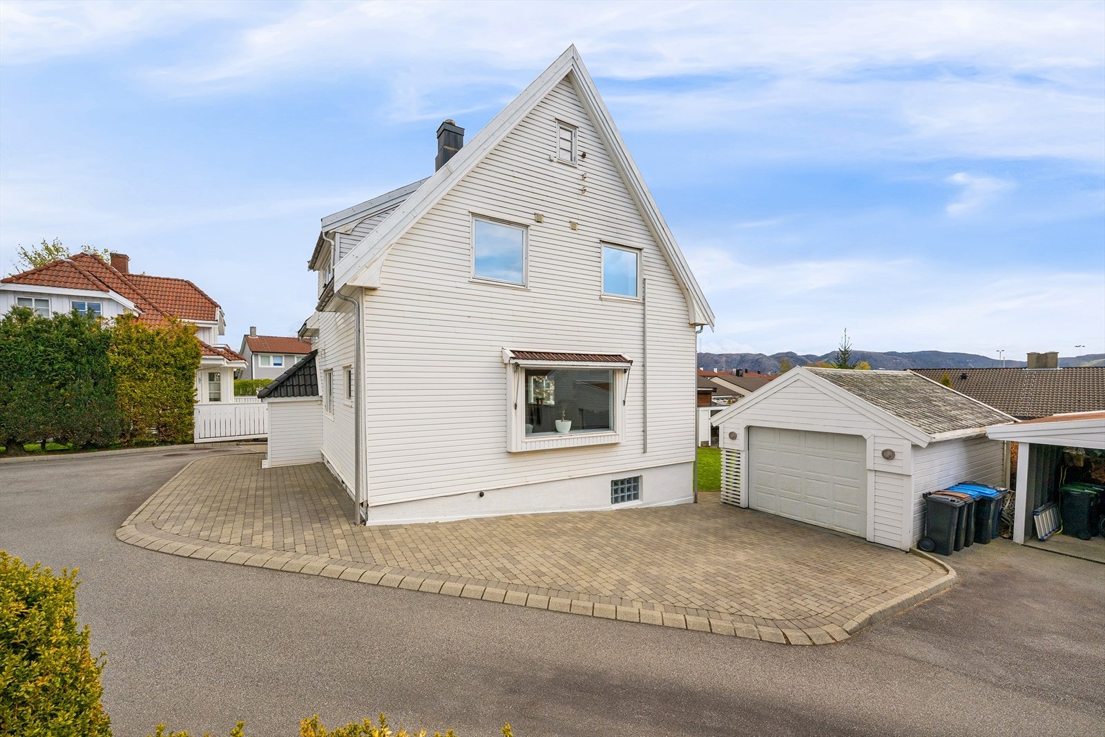Eiendommen har en romslig, belegningssteinbelagt gårdsplass med garasje og carport. Galleribilde