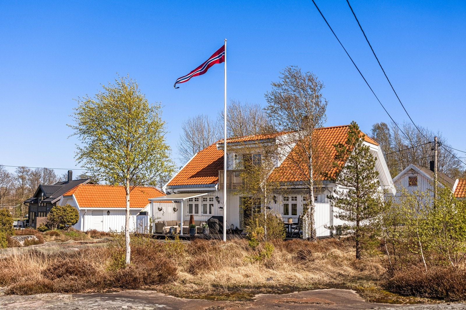 Tomten er en kombinasjon av asfaltert gårdsplass, naturtomt med svaberg og beplantning. Galleribilde