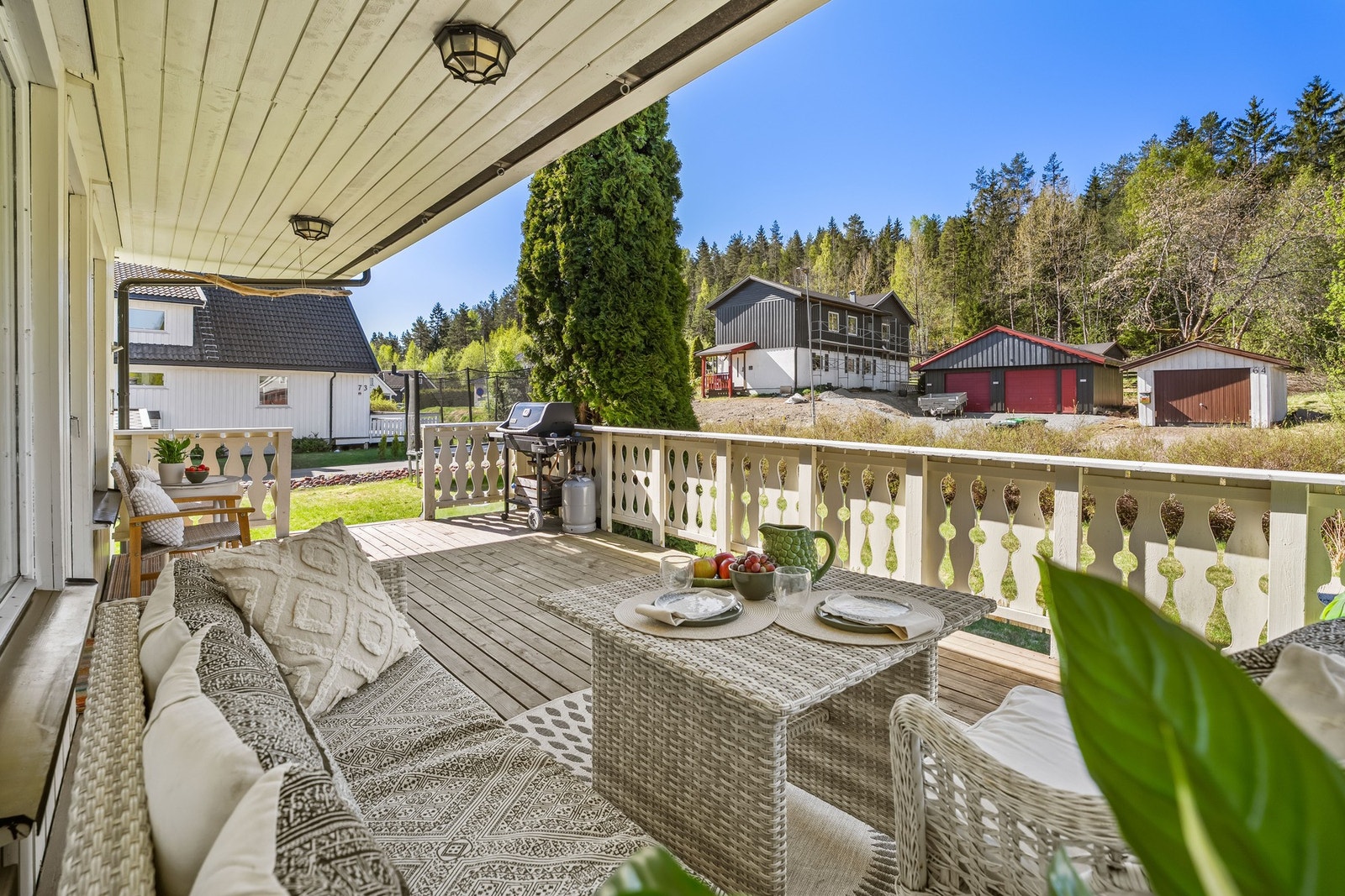 Overbygget veranda med hyggelig sittegruppe og utsyn mot rolige omgivelser og grøntområder. Galleribilde