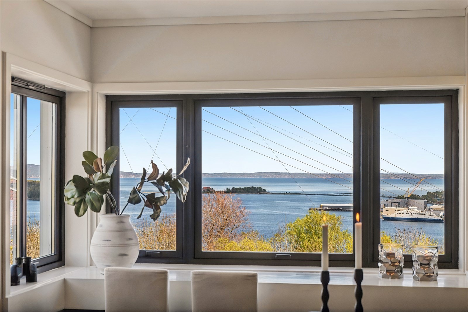 De store vindusflatene i stuen rammer inn en flott utsikt over fjorden. Galleribilde