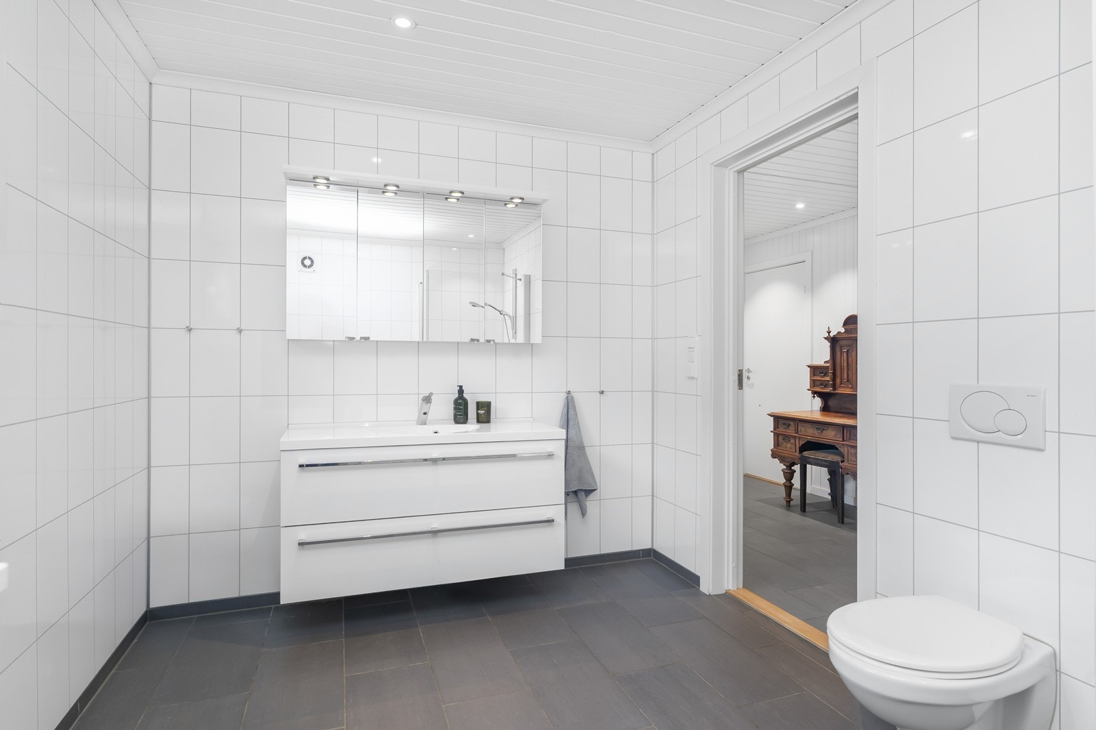 Badet har god størrelse. Flislagt gulv og plater på vegger. Galleribilde