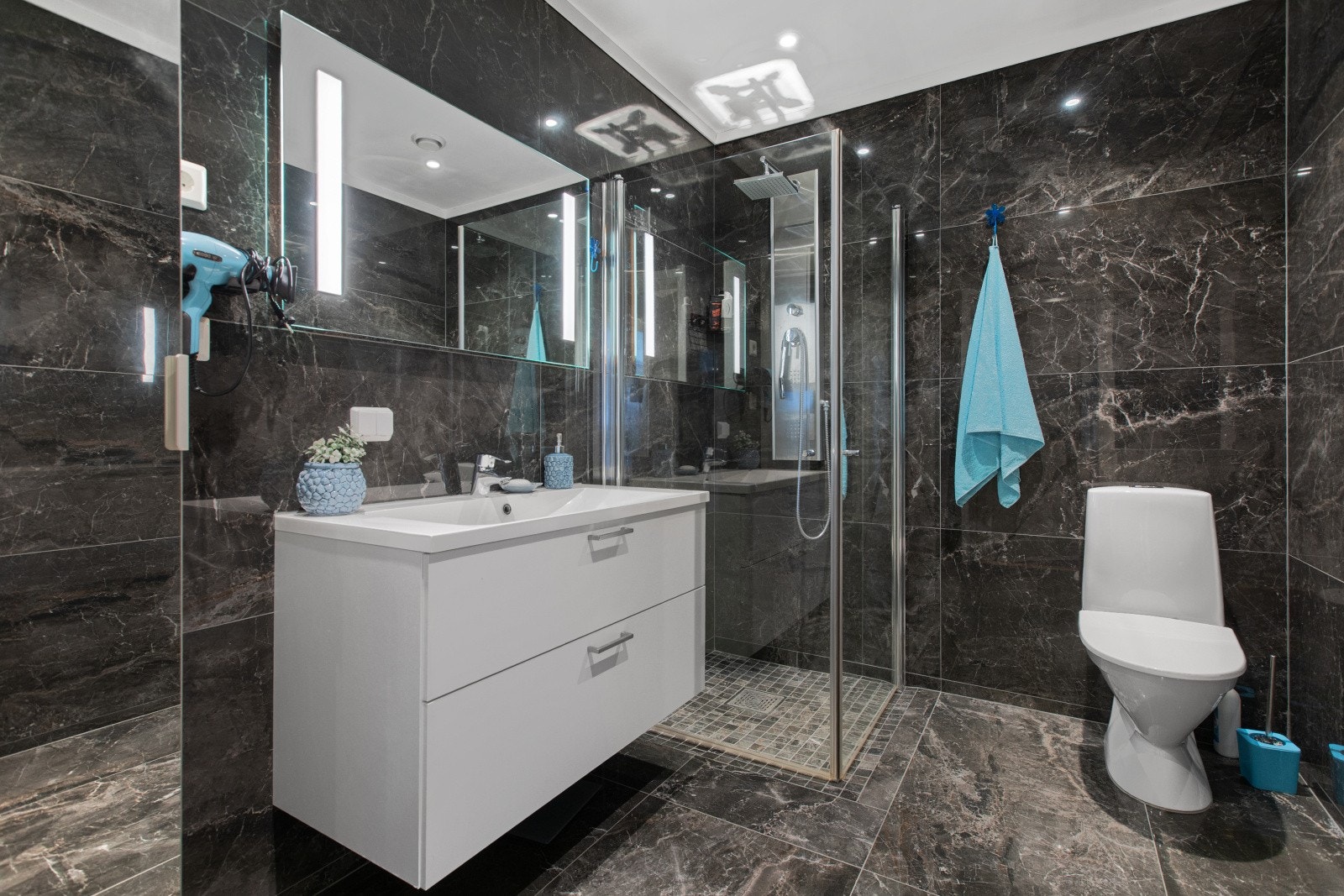 Badet i 1. etasje er fra byggeår med keramiske fliser på gulv og vegger. Det ble lagt flis på flis på veggene i 2020 av eier da det var ønskelig med et annet utseende. Gulvfliser ble fjernet og det ble lagt ny smøremembran og lagt nye gulvfliser. Galleribilde