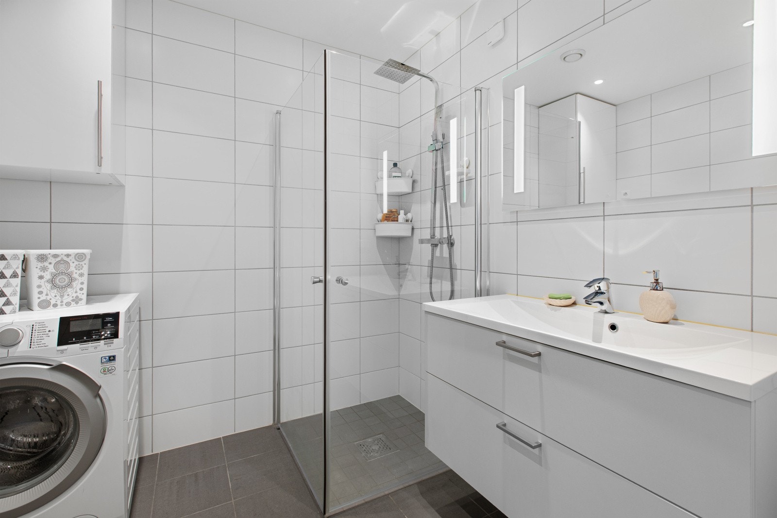 Badet i andre etasje er fra byggeåret 2019, med keramiske fliser, nedfelt servant, vegghengt toalett og innfellbare dusjdører med blandebatteri på vegg. I tillegg er det opplegg for vaskemaskin i rommet. Galleribilde