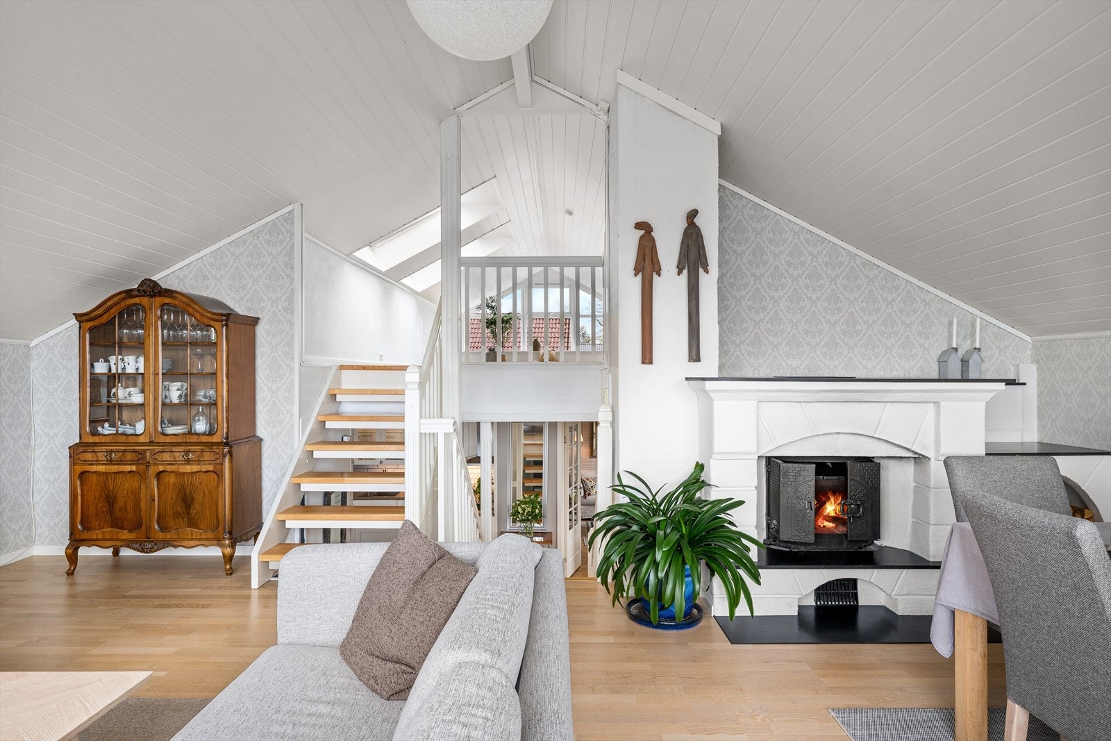 Loftstuen og stuen er et lunt og åpent rom med peis. Galleribilde