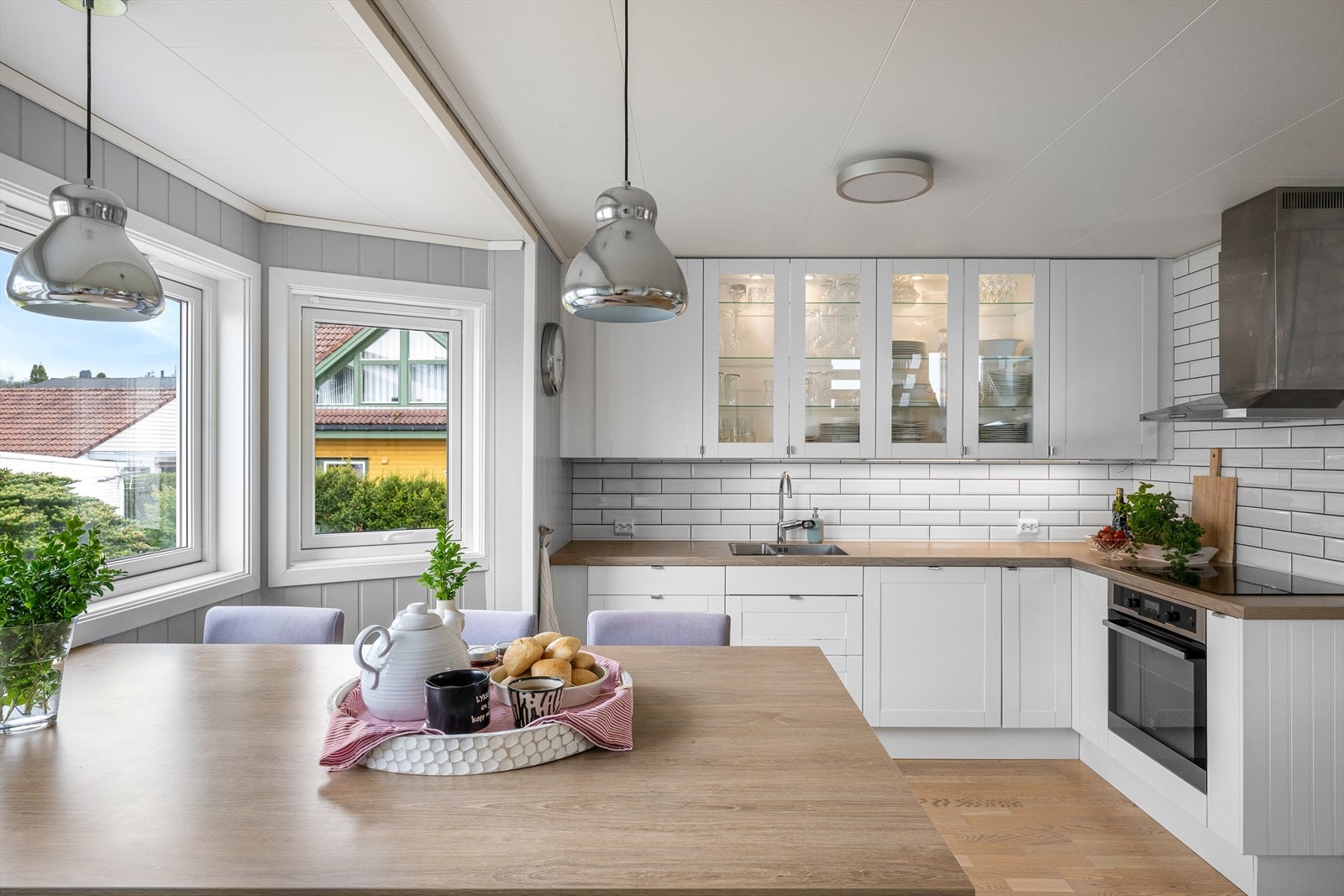 Kjøkkeninnredningen er i hvit utførelse med vitrineskap og nedsenket stålvask. Galleribilde