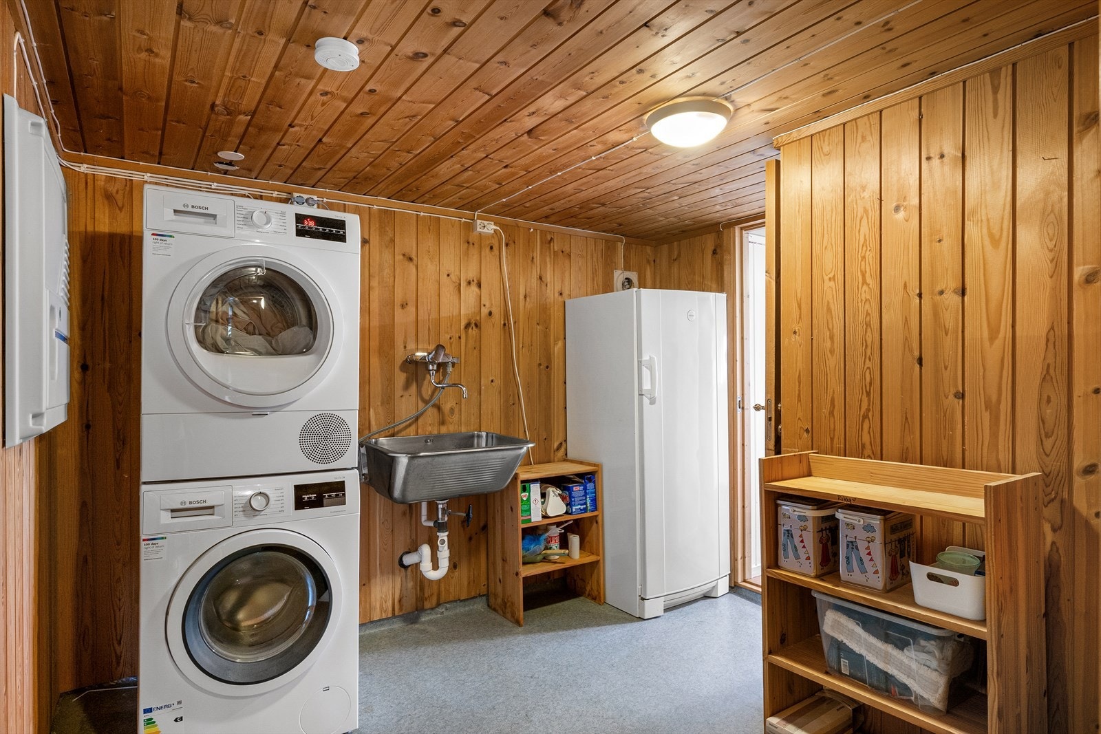 Separat vaskerom med utslagsvask i stål og opplegg for vaskemaskin. Galleribilde