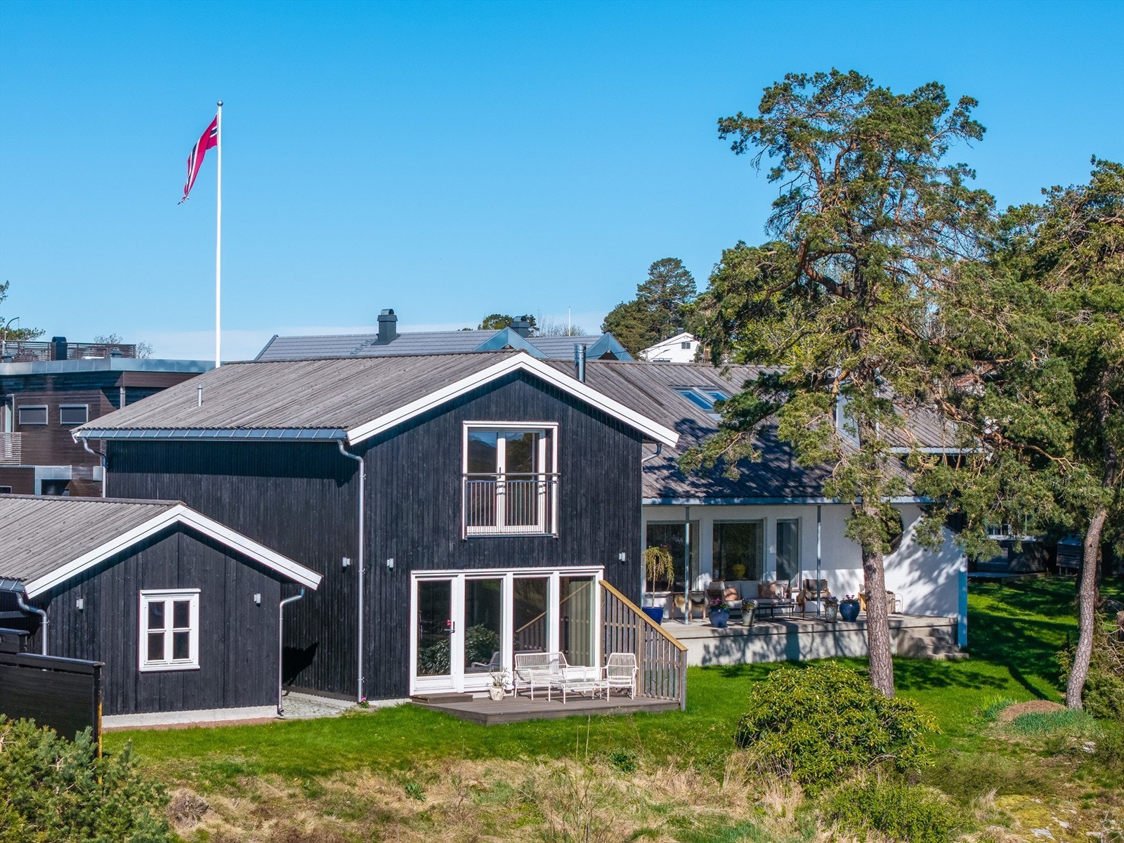 Tilbygget fra 2015 har stående rustikk kledning som ble malt i 2025. Galleribilde