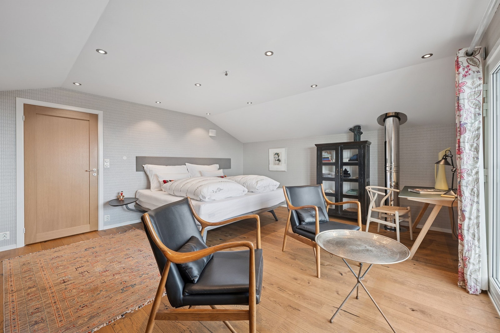 Hovedsoverommet i tilbygget er romslig, med plass til en liten sittegruppe. Galleribilde