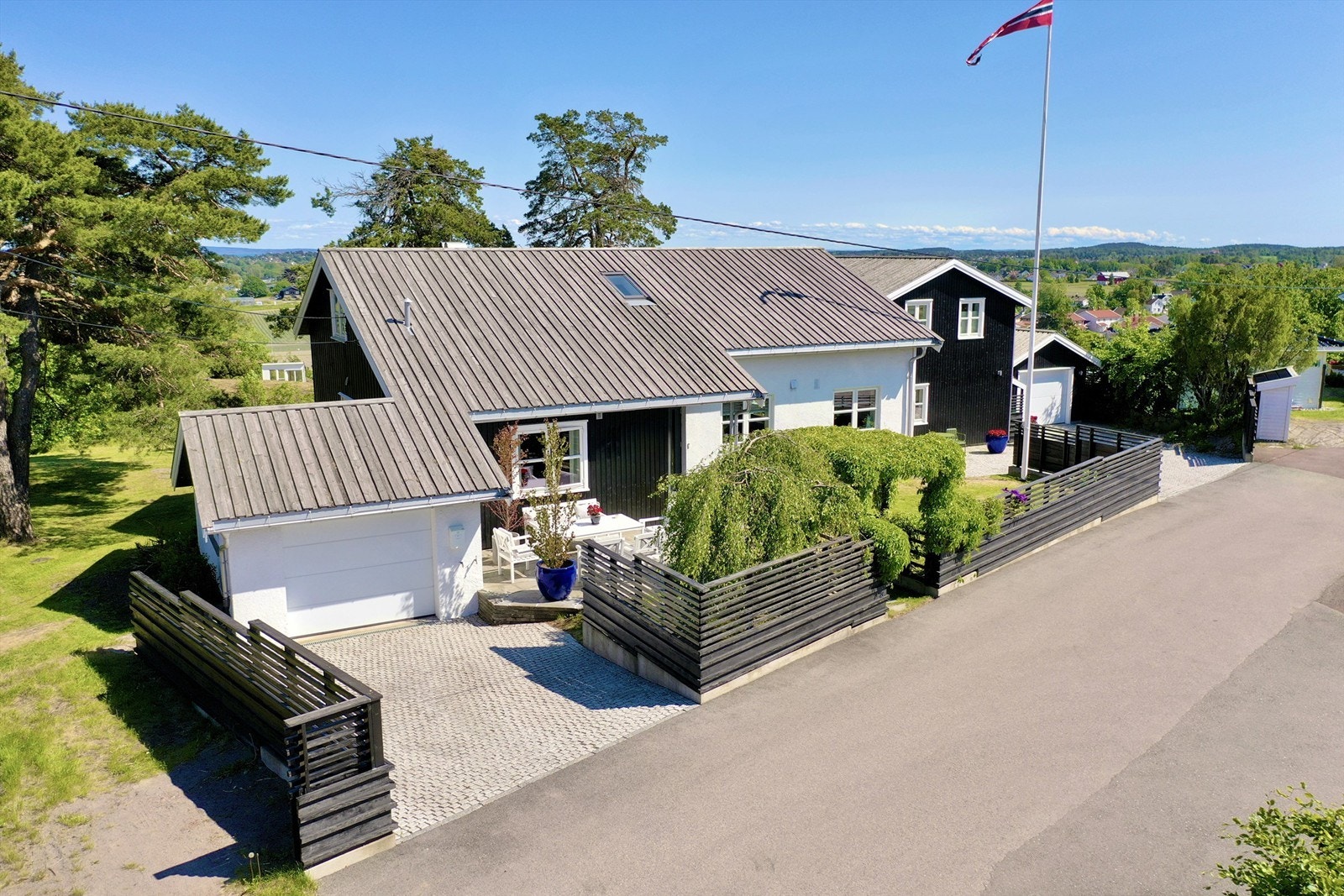 Eiendommen har en bred innkjørsel med belegningsstein og parkeringsmuligheter. Galleribilde