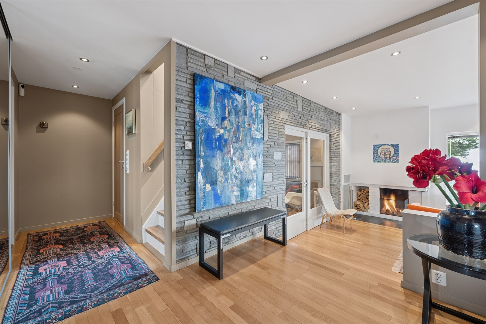 Fra hallen åpner boligen seg mot stuen, hvor en åpen peis er et sentralt element. Galleribilde