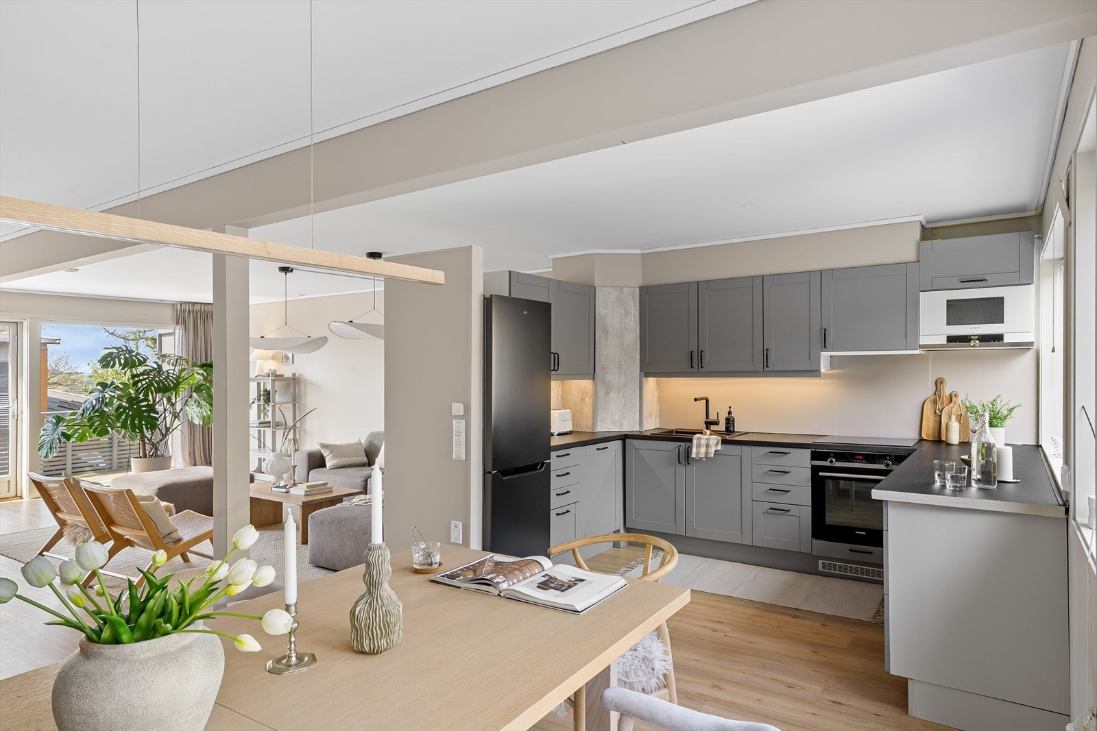 Kjøkkeninnredningen ble i 2022 fornyet med grå, profilerte fronter, og sort benkeplate av laminat med nedfelt oppvaskkum. Galleribilde