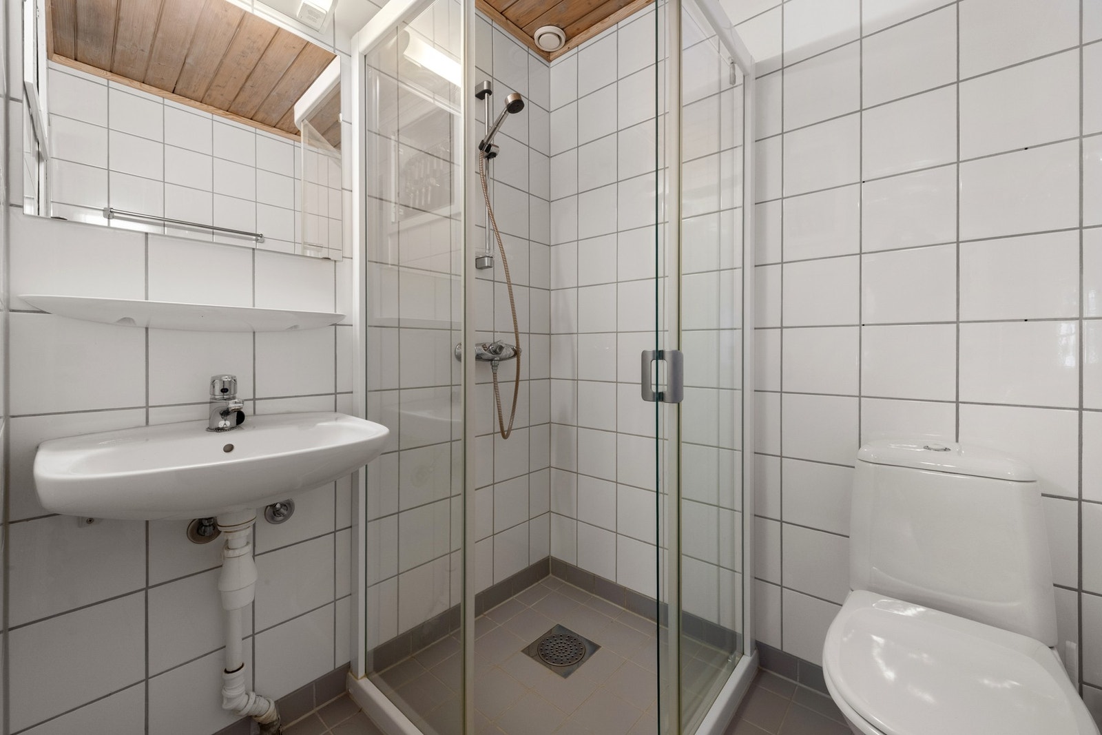 Badet har dusjnisje, enkel servant og gulvstående toalett. Galleribilde