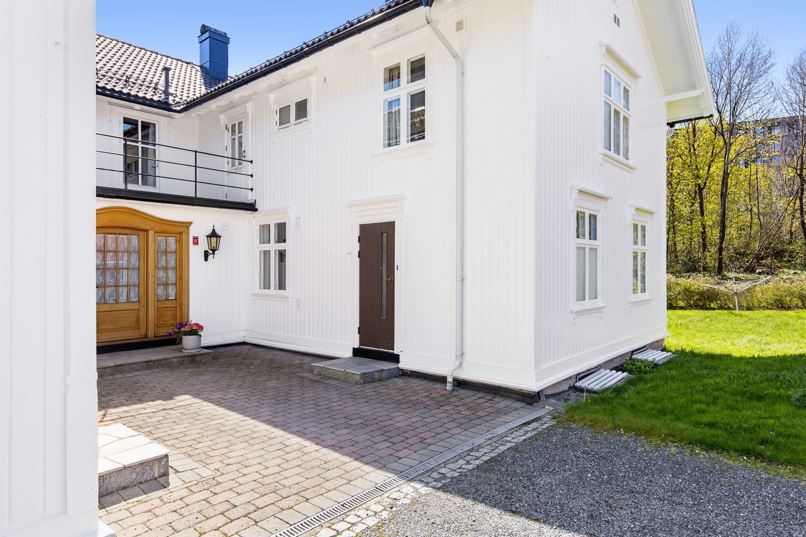 Flott gårdsrom med belegningsstein mellom de store fløyene til hovedhuset. Galleribilde