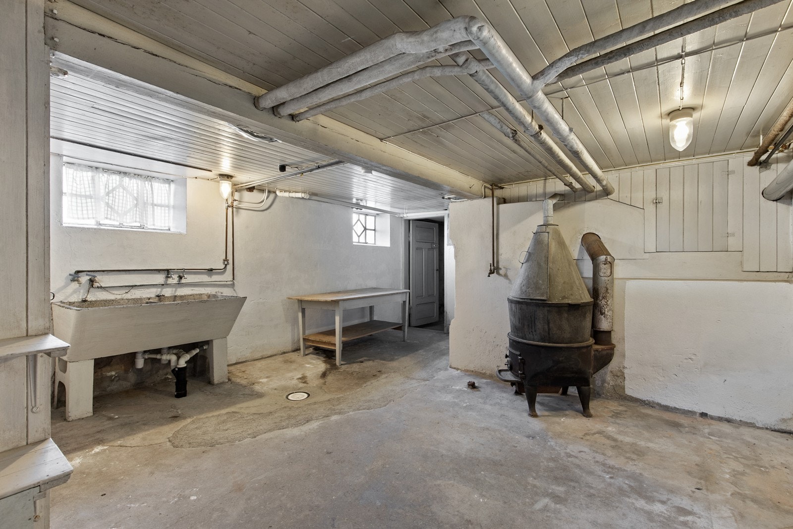 Kjeller med god takhøyde, her er den gamle kjelen og vaskekummene fremdeles. Galleribilde