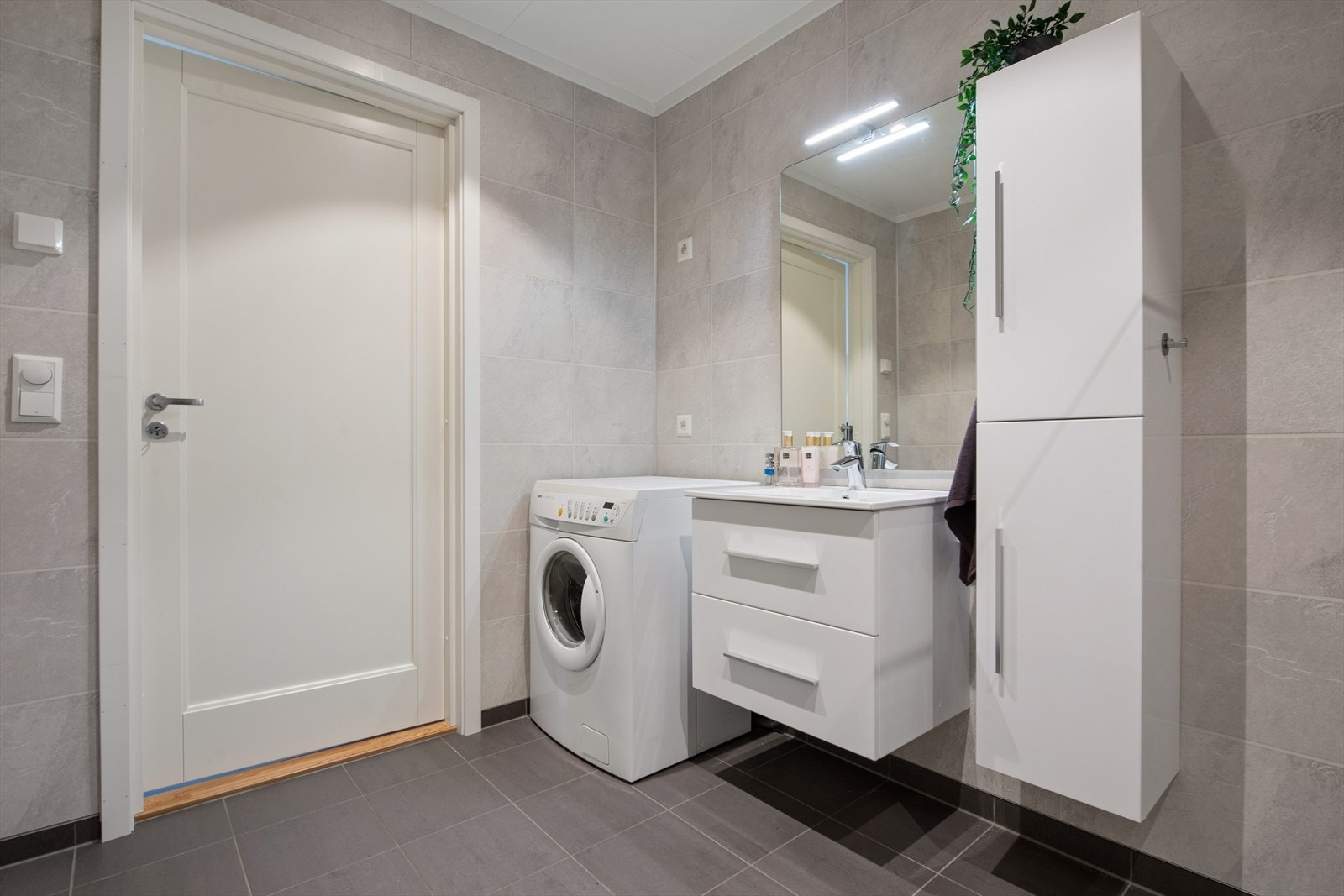 Badet er praktisk innredet med opplegg for vaskemaskin og god skapplass. Galleribilde