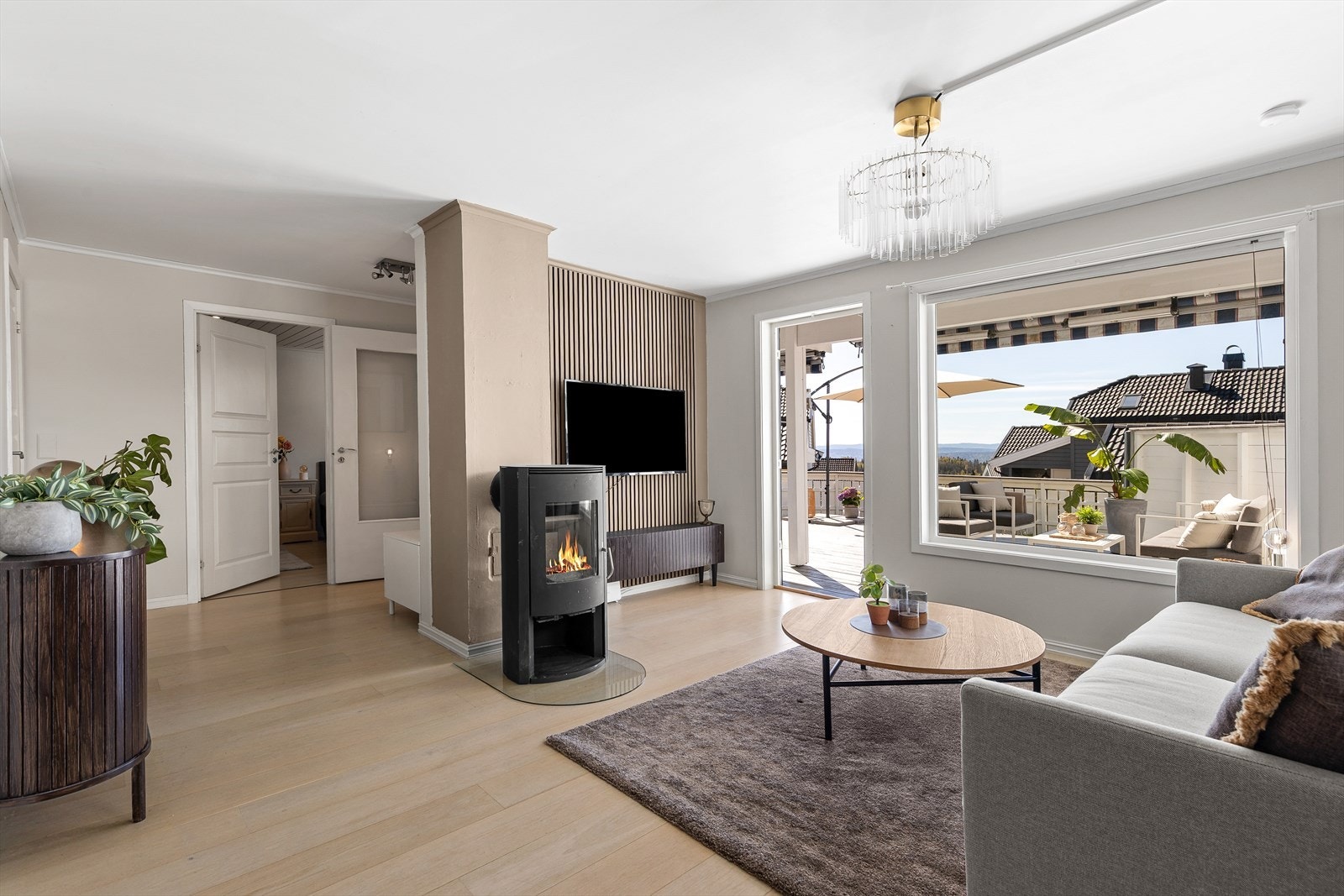 Den brede terrassedøren åpner opp mot uteplassen og slipper rikelig med dagslys inn i stuen. Galleribilde