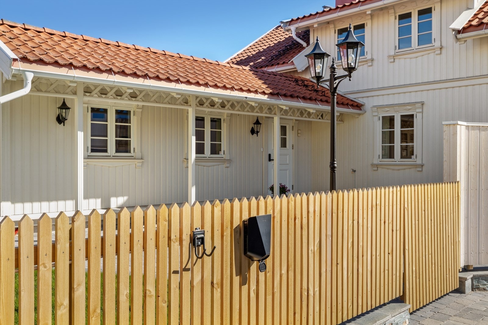 Parkeringsplass for 2 biler. Elbil lader montert på gjerde Galleribilde