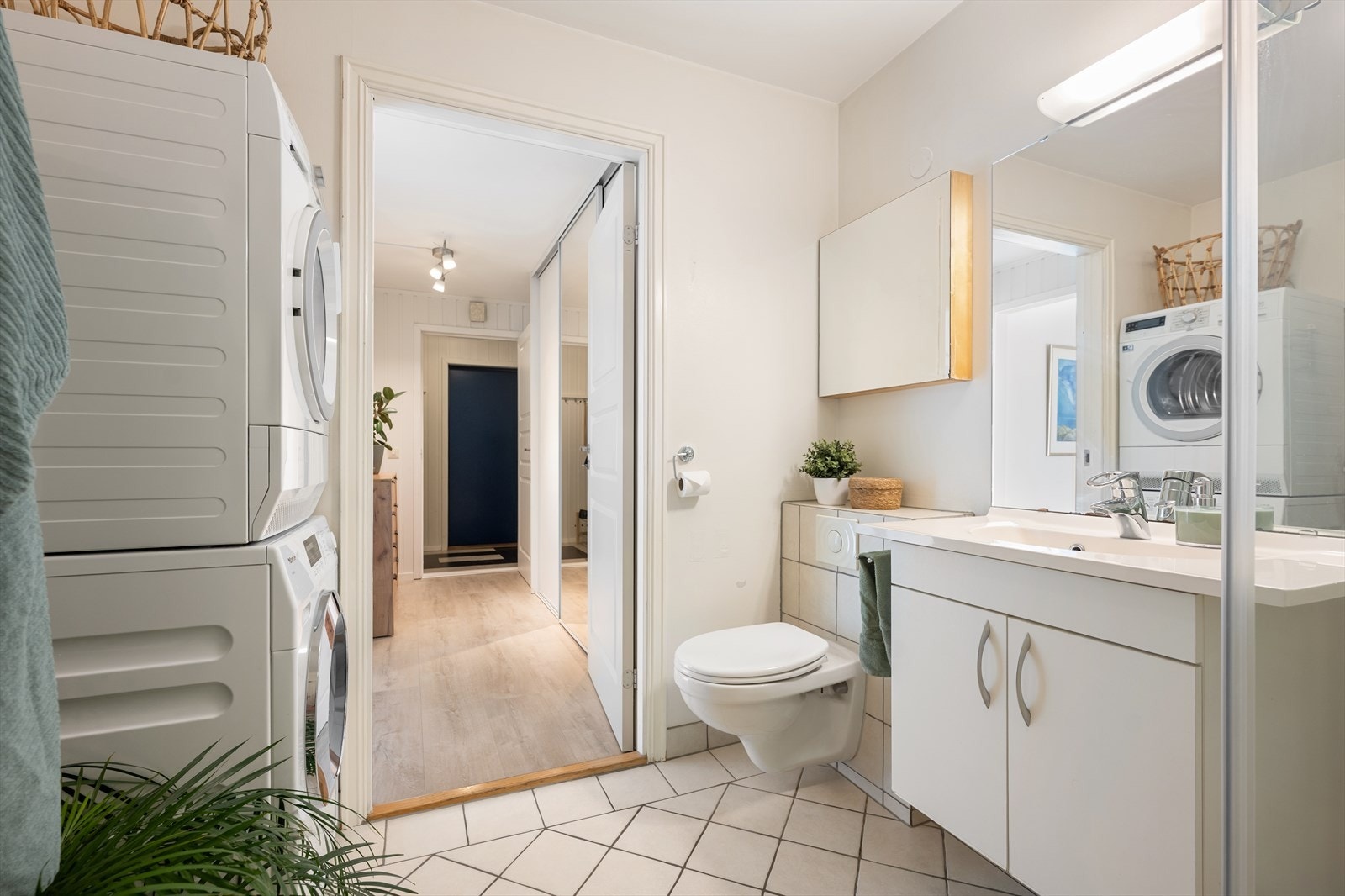 Romslig baderom med opplegg for både vaskemaskin og tørketrommel. Galleribilde