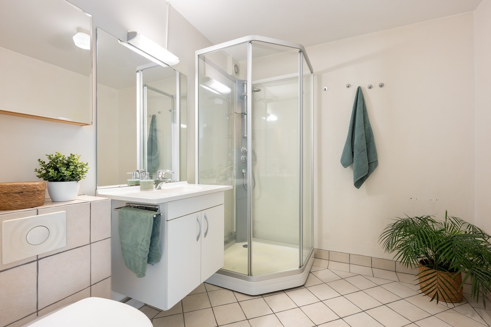 Badet er utsyrt med varmekabler, dusjkabinet, servant og toalett. Galleribilde