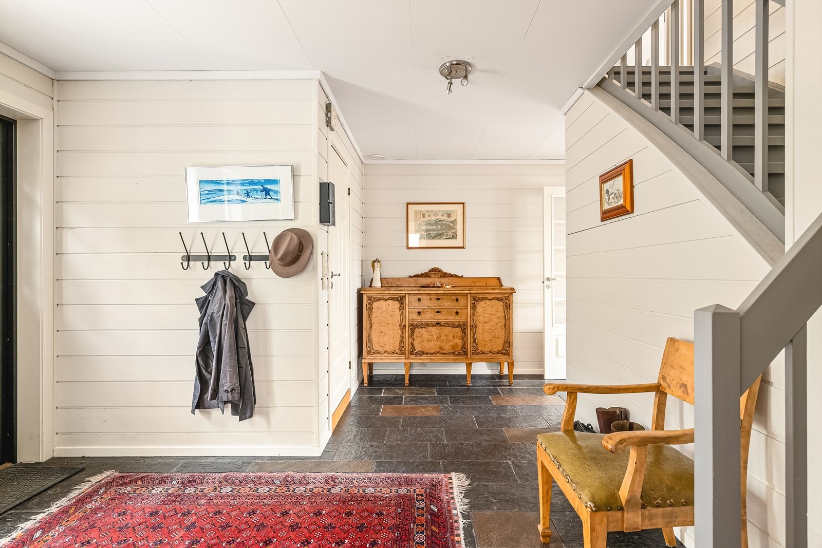 Gangen er romslig, lys og luftig og leder videre inn til etasjens rom, samt til trapp både opp i andre- og ned i kjelleretasjen. Galleribilde