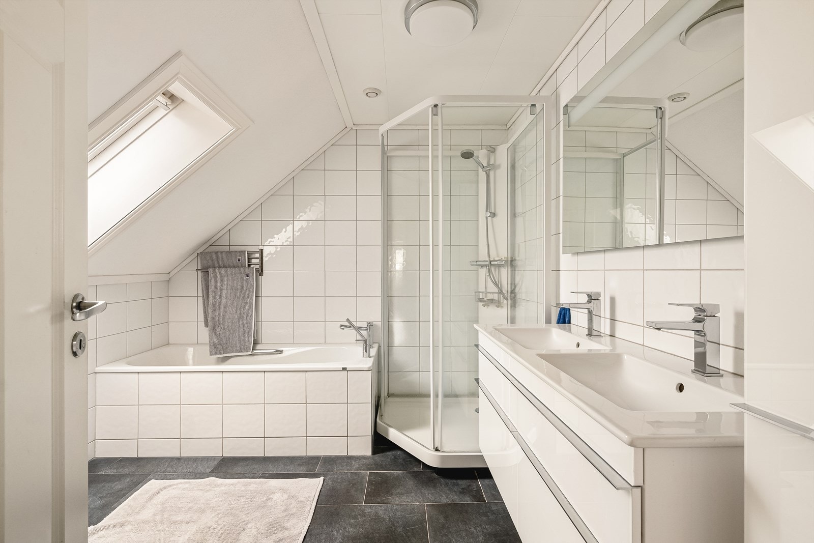 Innredet med toalett, dusjkabinett, badekar, heldekkende servant med 2 vasker, speil med belysning og godt med oppbevaring. Galleribilde