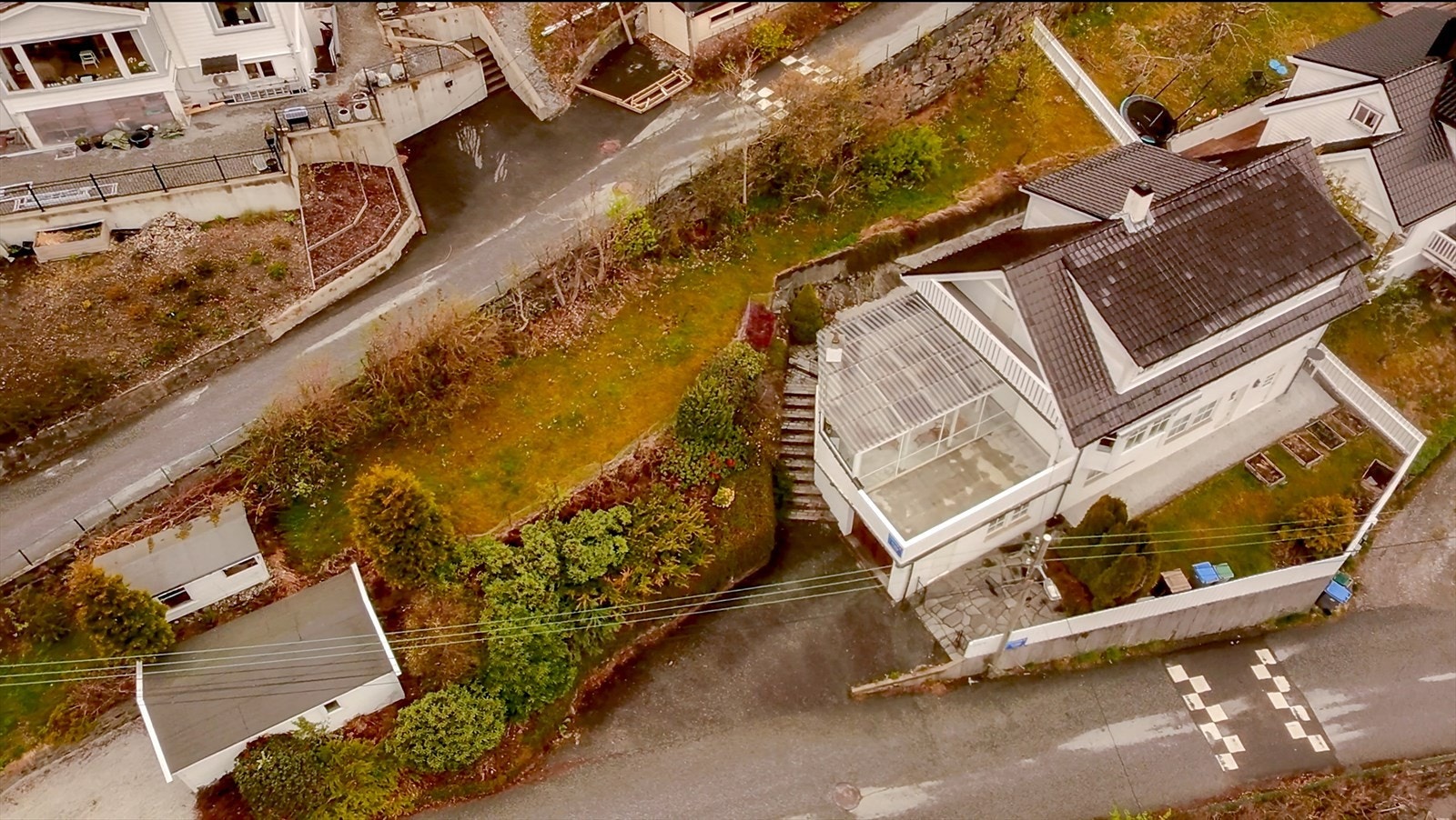 Pent opparbeidet tomt med hage både foran og bak. Pene murer og beplantning. Hagestue på terrassen, integrert- og frittstående garasje og lekehus/utebod. Fotokredit: Sverre Skilbreid. Galleribilde