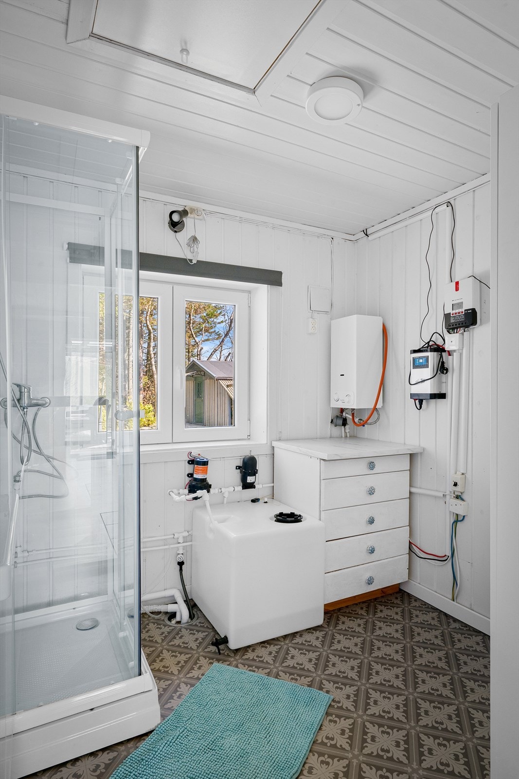 Bad i enkel standard med vask og dusj. Vannforsyning via vanntank, med gassdrevet oppvarming av varmtvann. Galleribilde