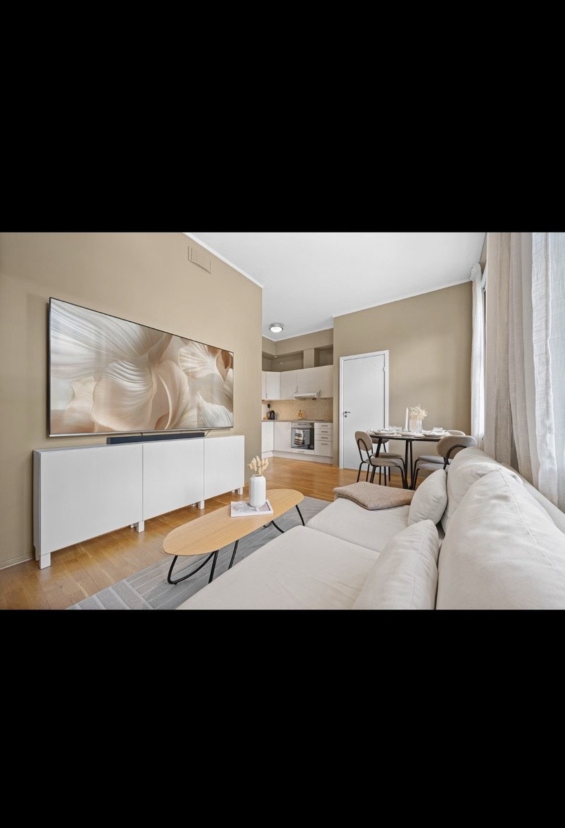 Stuen. Leiligheten kommer med en 65" TV fra Samsung + diverse strømmetjenester. Rommet har en takhøyde på 2,97m Galleribilde