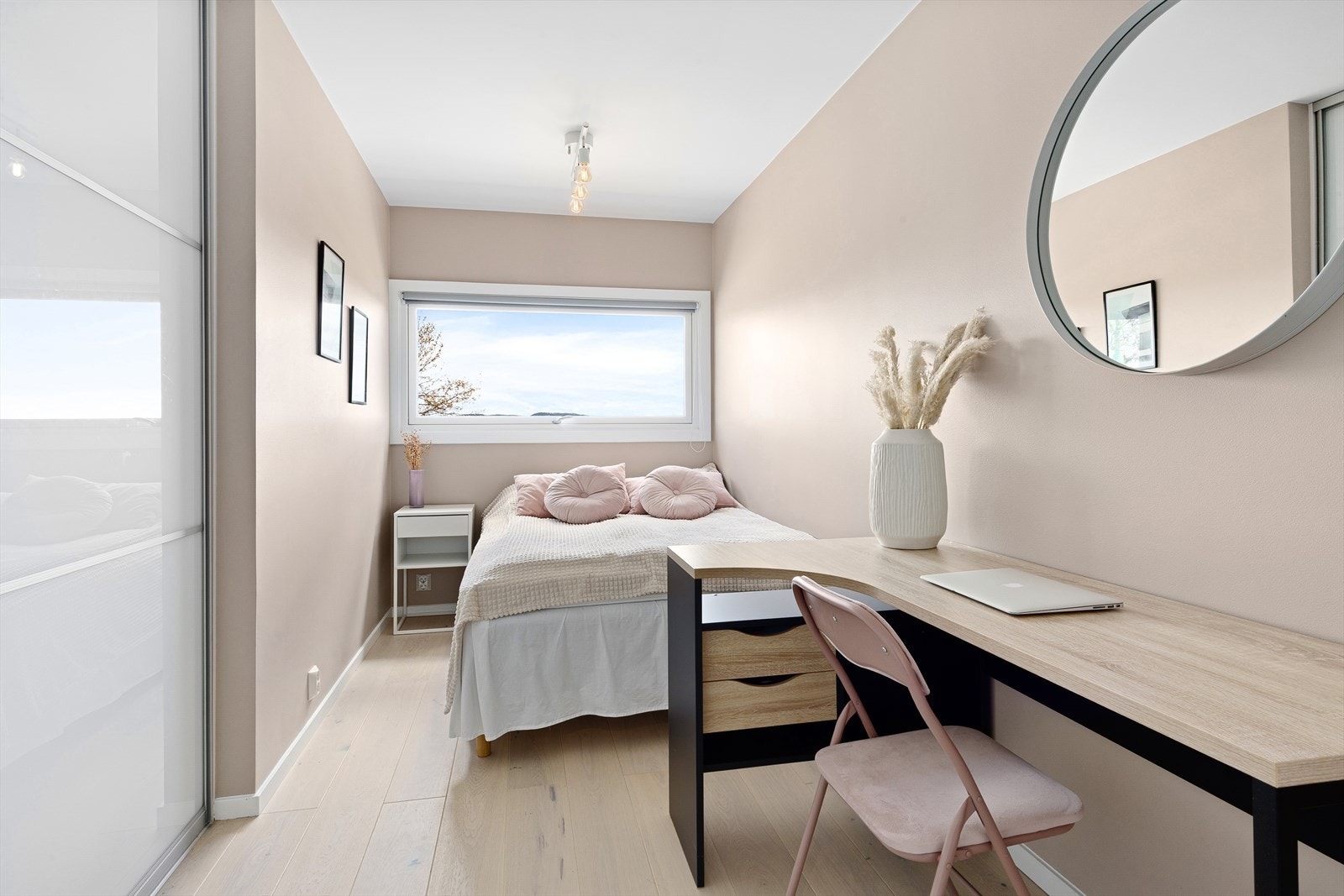 Det ene soverommet er innredet med en praktisk skyvedørsgarderobe med glatte dører. Galleribilde