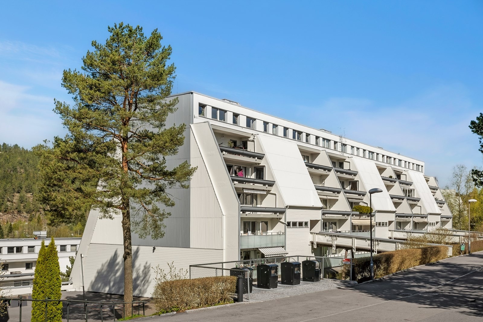 Bygget har en karakteristisk terrassearkitektur. Leiligheten disponerer egen garasjeplass under bygget. Galleribilde
