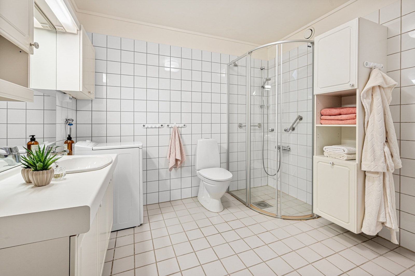 Badet er utstyrt med servantinnredning, gulvmontert toalett og dusjhjørne. Galleribilde