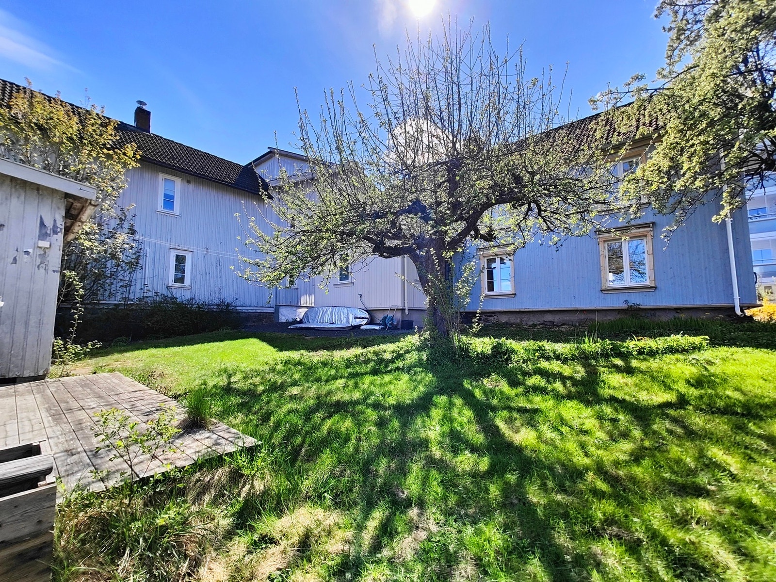 På tomten er det i tillegg et uthus/skur i hjørnet mot øst. Om sommeren er hagen i vekst og man har både pærer, epler og plommer. I tillegg er det beplantet med prydbusker og stauder Galleribilde