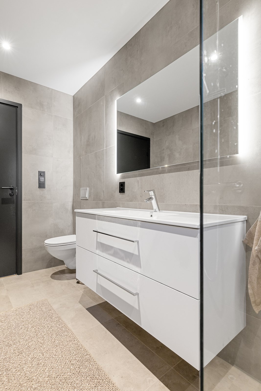 Boligen har 2 delikate baderom i hver sin etasje. Det flislagte badet i 1.etasje har elektriske varmekabler og downlightsbelysning som gir en lun atmosfære under morgenstellet. Galleribilde