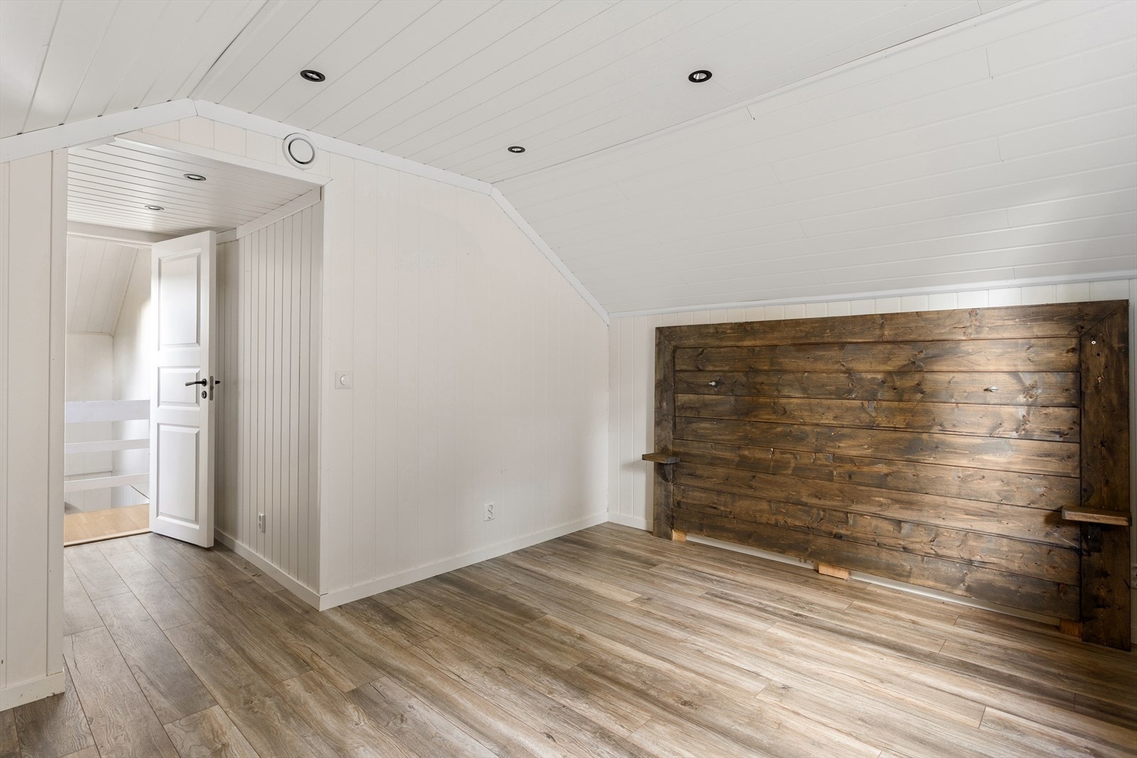 Et av de innredede rommene i andre etasje, med panelvegger og laminatgulv. Galleribilde