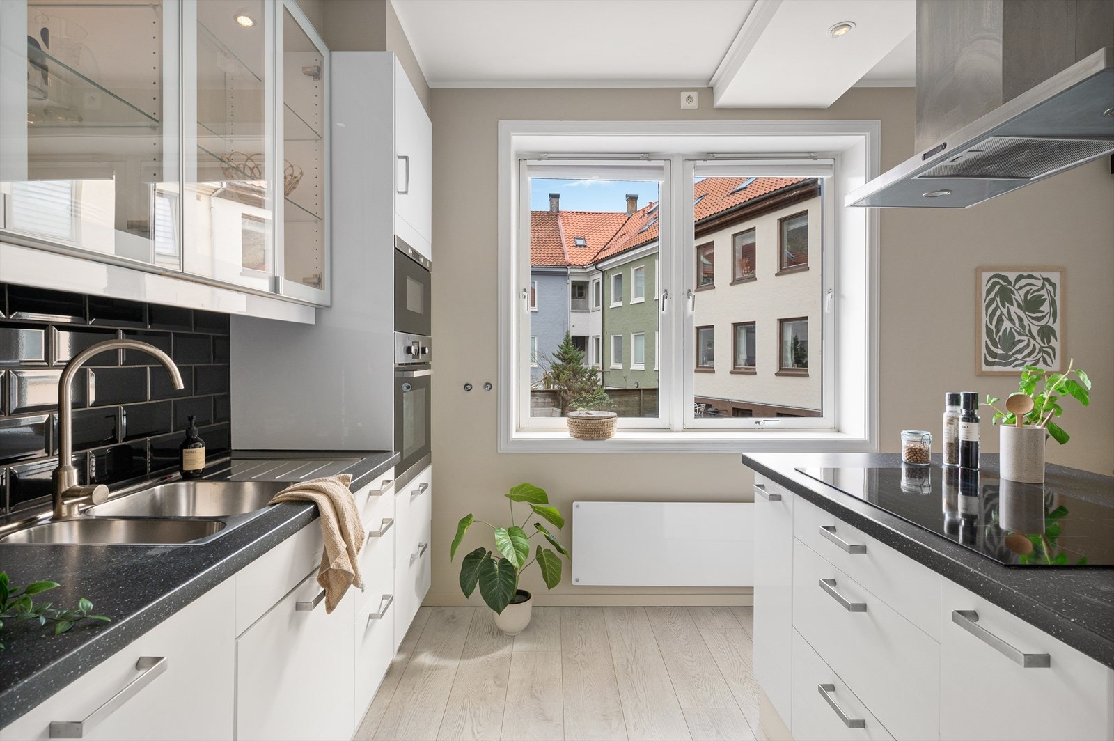 Over benkeplaten er det fliser, samt praktisk belysning og stikkontakter under overskapene. Galleribilde