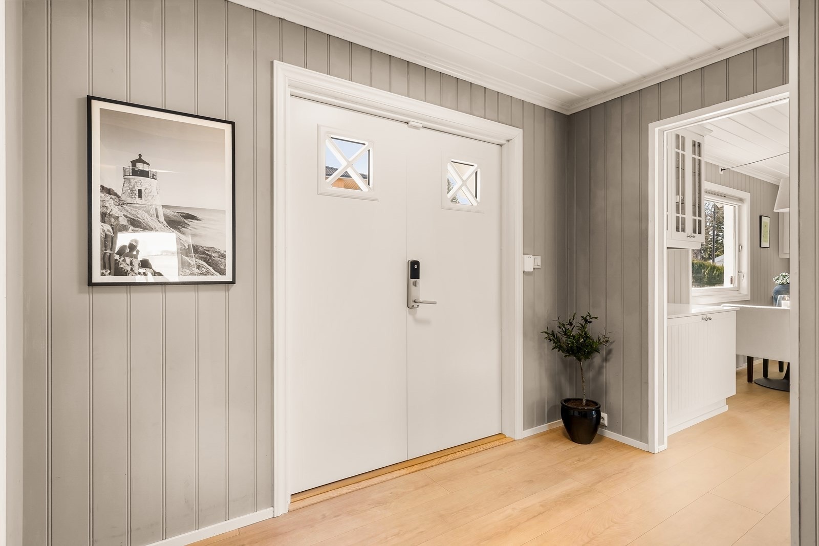 Hovedinngangen ønsker velkommen med en malt tofløyet dør med kodelås fra Yale doorman, som leder inn til husets første etasje. Galleribilde