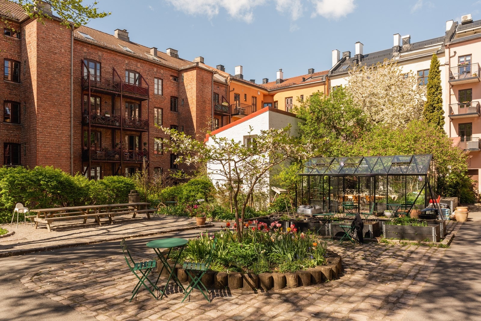 Bakgården er pent opparbeidet med grillplass og flere sittegrupper til felles bruk. Galleribilde