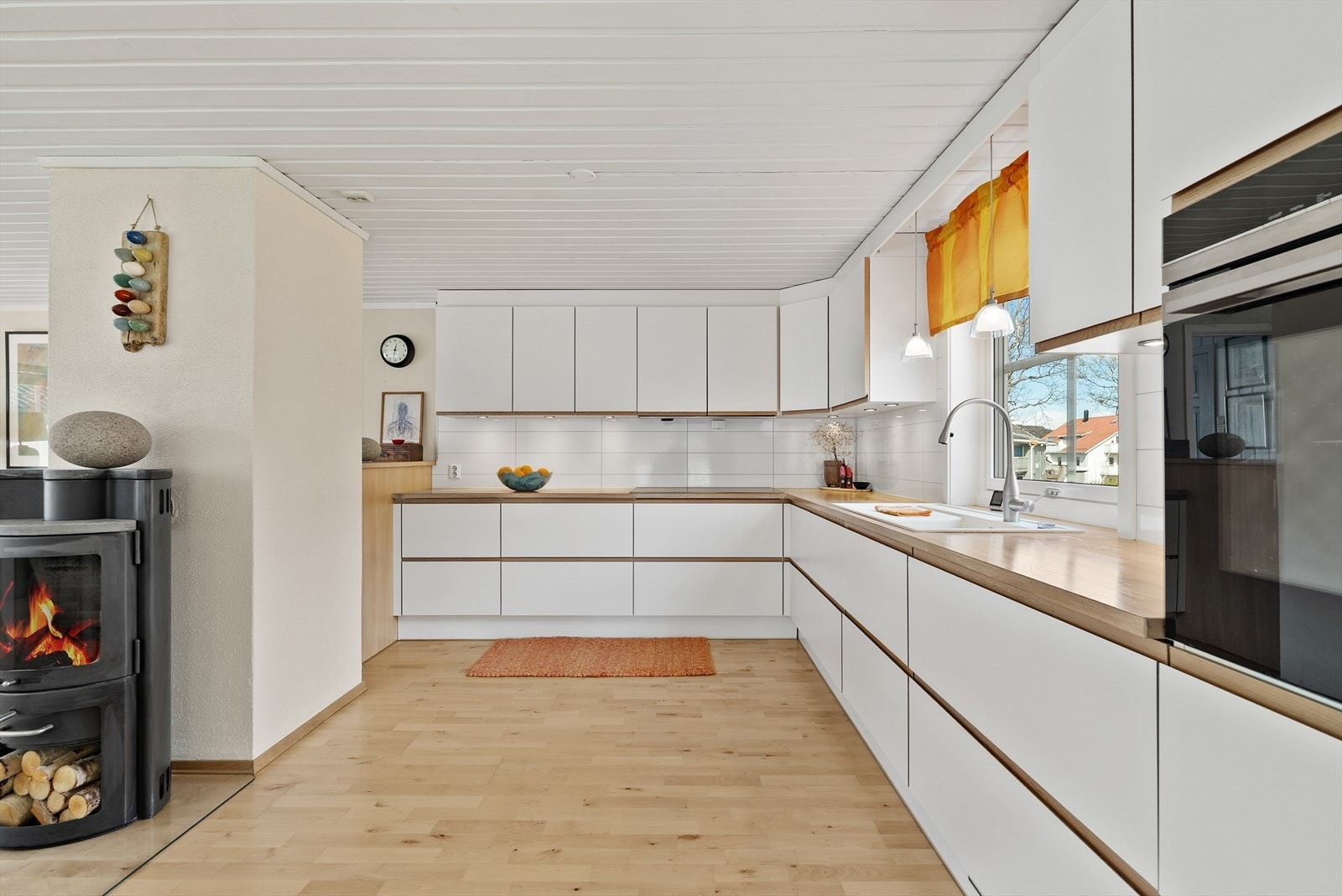 Kjøkkenet har en lys innredning med glatte fronter og benkeplate av heltre. Galleribilde