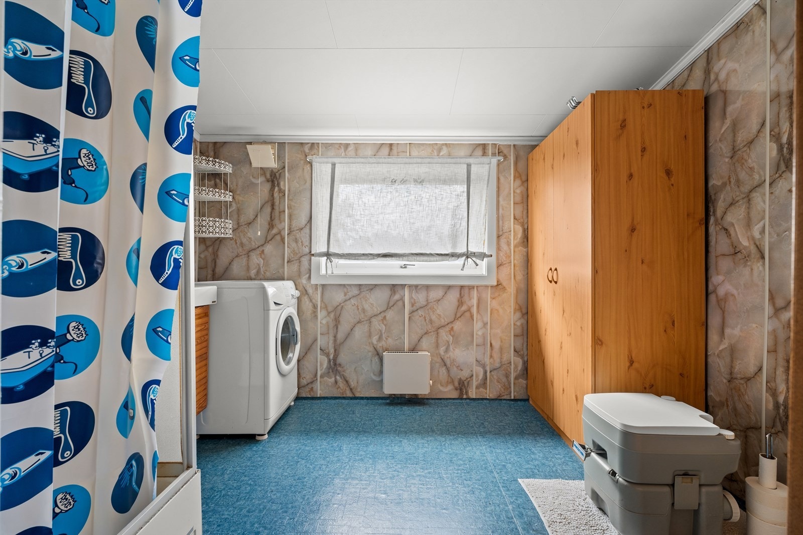 Badet er utstyrt med dusjkabinett, servantinnredning og opplegg til vaskemaskin. Galleribilde