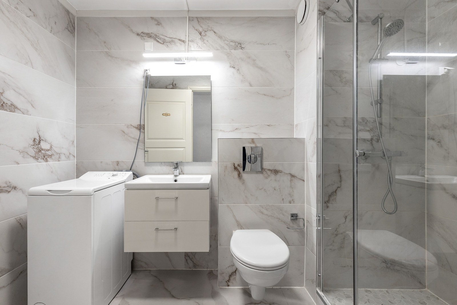 Badet er innredet med flislagte gulv og vegger. Galleribilde