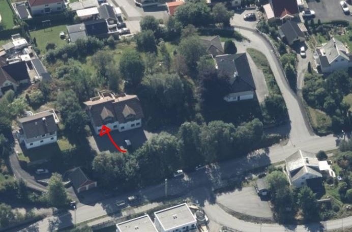 Huset ligger bak trærne. Parkering foran huset mot nord. Inngang bak mot sør. Galleribilde