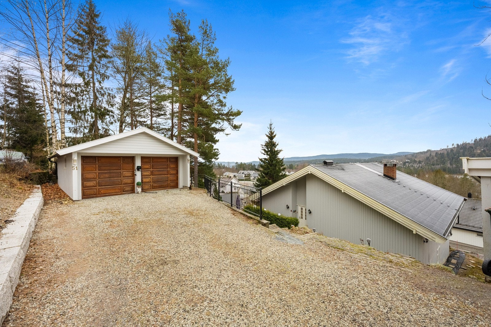 En romslig familiebolig med stor, skrånende tomt og en frittstående dobbelgarasje med el-lader.
Foto: Isnitt.no Galleribilde