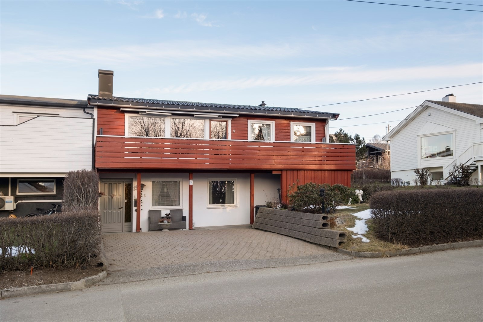 Inngangspartiet har belegningsstein og en malt hovedytterdør med sidevindusfelt. Galleribilde