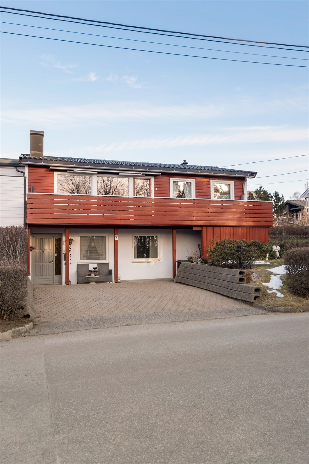 Boligen har en fasade med liggende bordkledning og en balkong med vindusfelt. Galleribilde